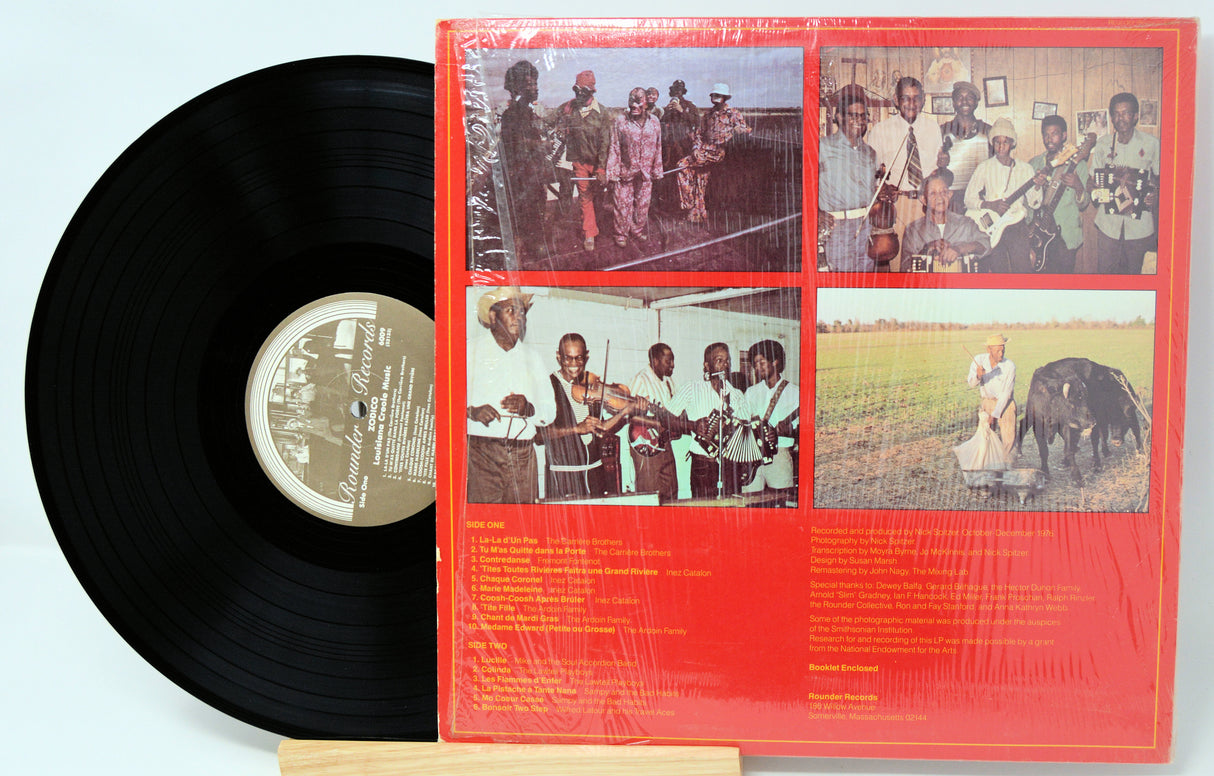 Vinyl record with a red cover featuring black and white photos of people and animals.