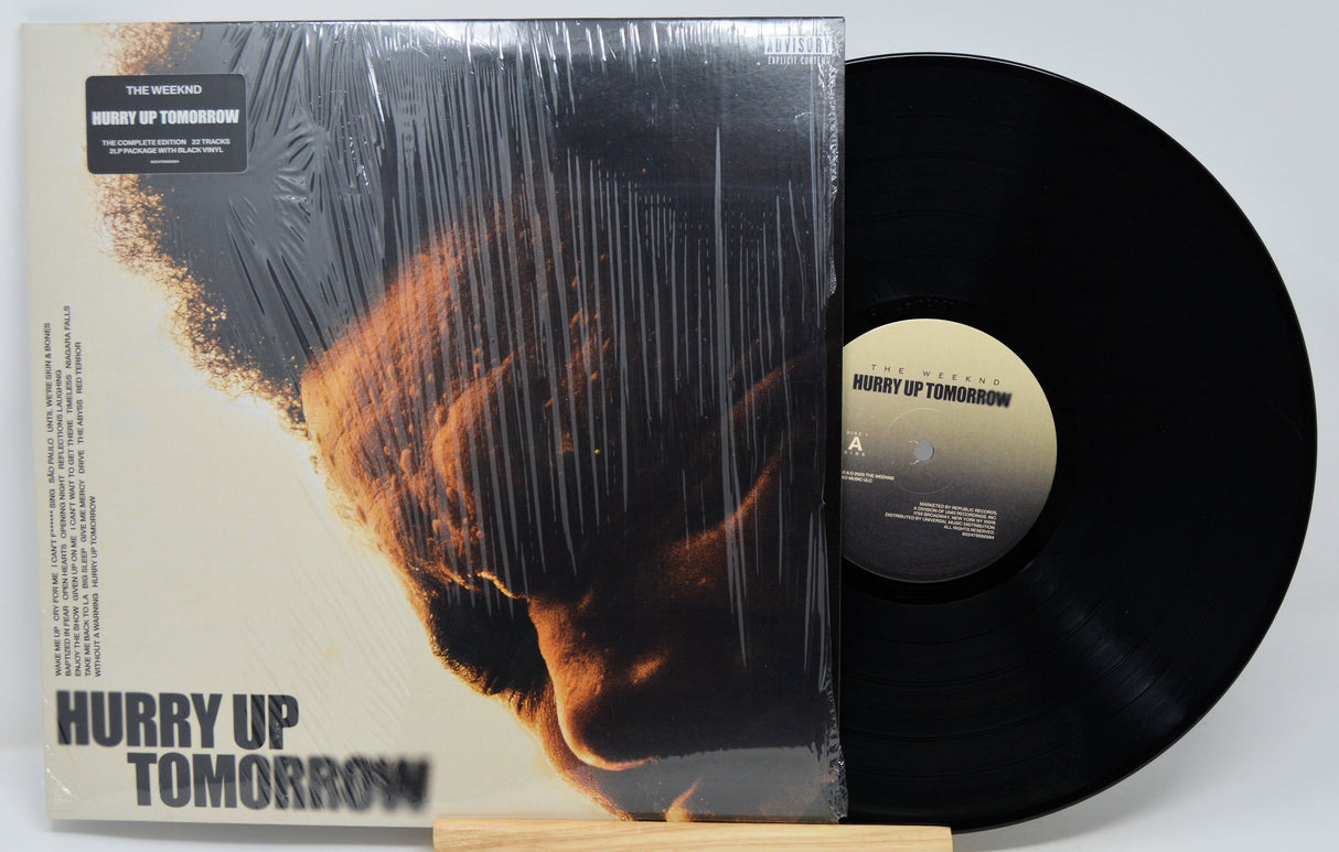 Vinyl record and cover titled 'Hurry Up Tomorrow' by The Weeknd on a white background