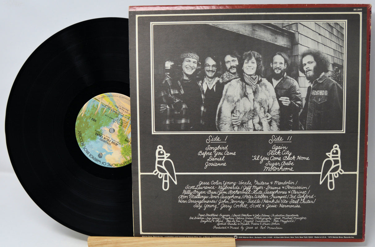 Vinyl record with cover featuring a group of people and track listings.