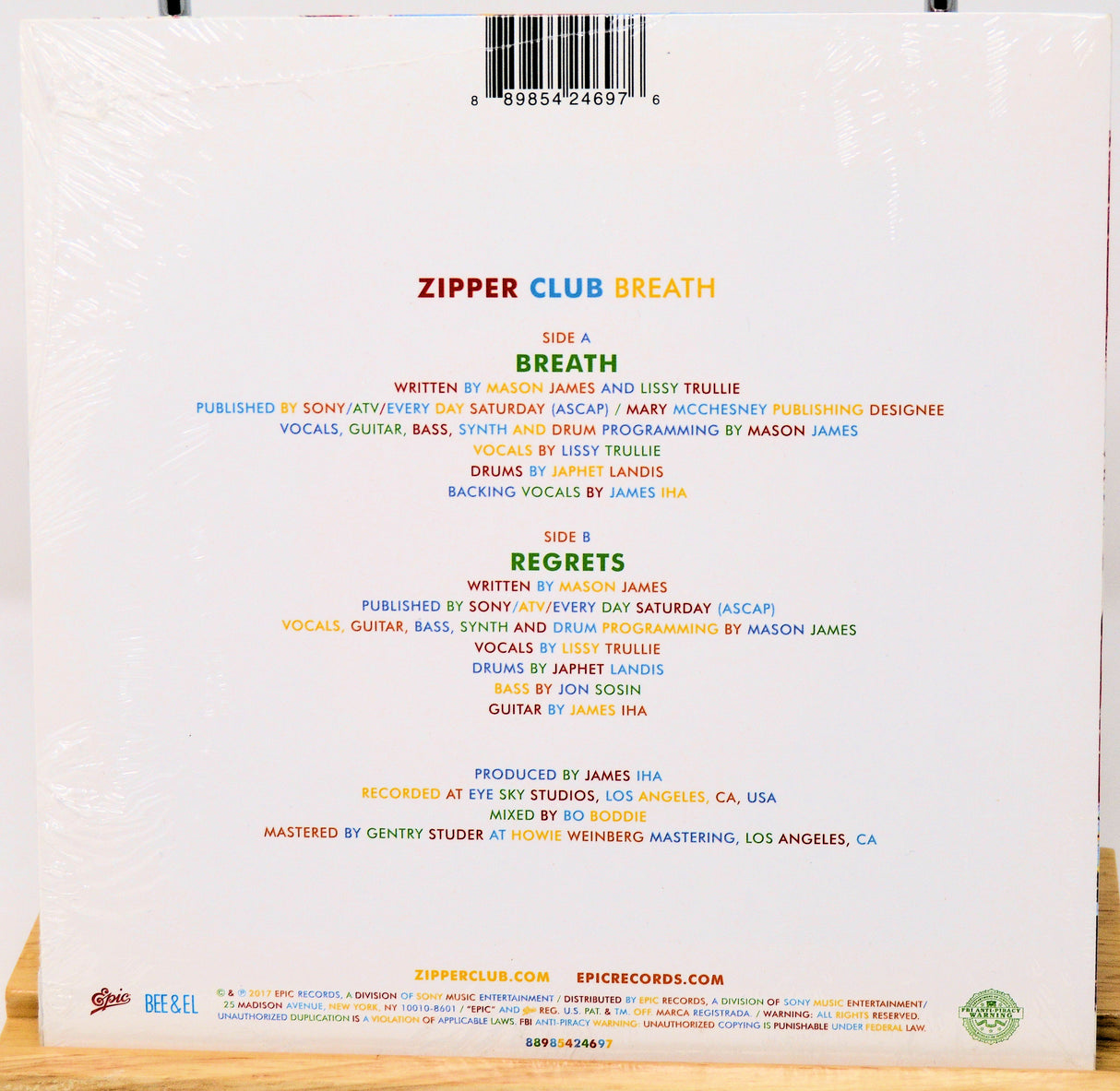 Back cover of a music album with tracklist and production credits on a white background