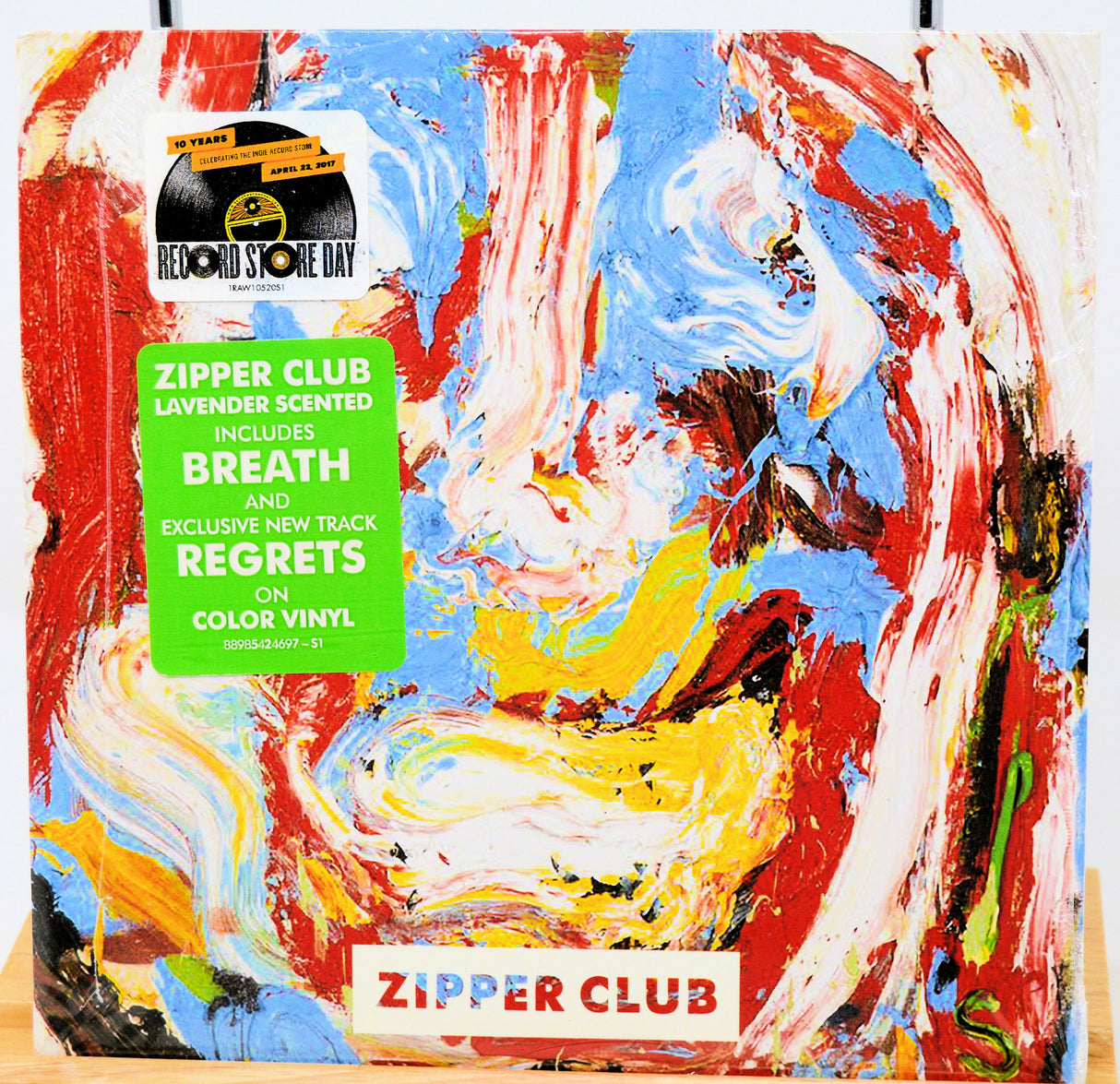 Colorful vinyl record packaging with 'Zipper Club' branding, colorful abstract art and text.