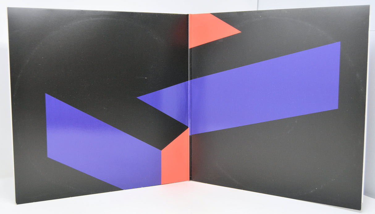 Vinyl record called 'Shape Shift' by Zombi with red and blue geometric shapes on a black background.