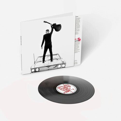 Black and white album cover featuring a person standing on a car with a raised guitar in the air.