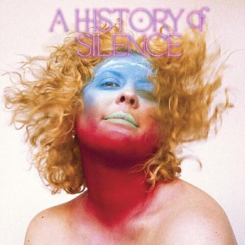 The image features the cover art for 'A History of Silence' by Sibille Attar. It displays a striking and evocative portrait of the artist with a bold, red and blue makeup look, her hair styled in a lion's mane, framed by a simple, textured white background.