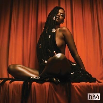 A vinyl record cover featuring the artist Kelela with a red background. She is wearing a necklace and has a performance-oriented pose.