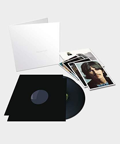 A new vinyl record of The Beatles - White Album with its packaging and a set of picture cards laid out next to it.