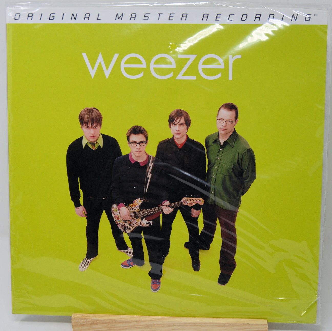 Weezer 'Original Master Recording' vinyl record cover in shrink wrap, featuring the band members against a bright yellow-green background.