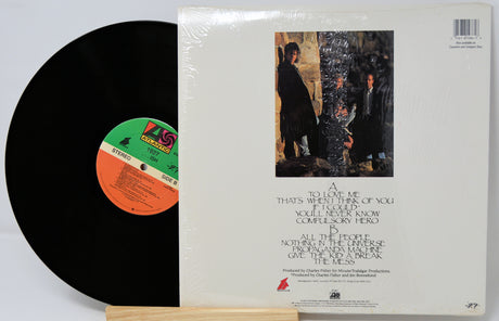 Vinyl record with cover featuring a black and white image of people and text.