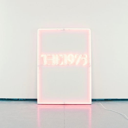 A clear vinyl record album packaging for 'The 1975' with a minimalistic design featuring the band's name in simplistic typography on a light background.