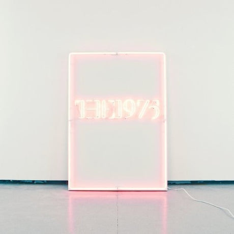 A clear vinyl record album packaging for 'The 1975' with a minimalistic design featuring the band's name in simplistic typography on a light background.