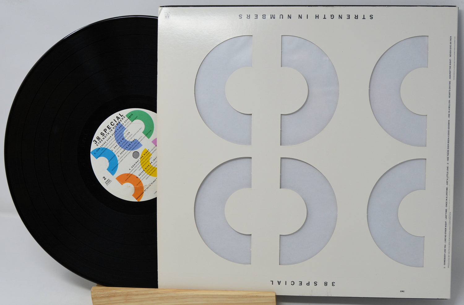 A vinyl record partially pulled from its sleeve, photographed on a light background. The sleeve is off-white with large geometric cutout shapes, and the record label reads Special.