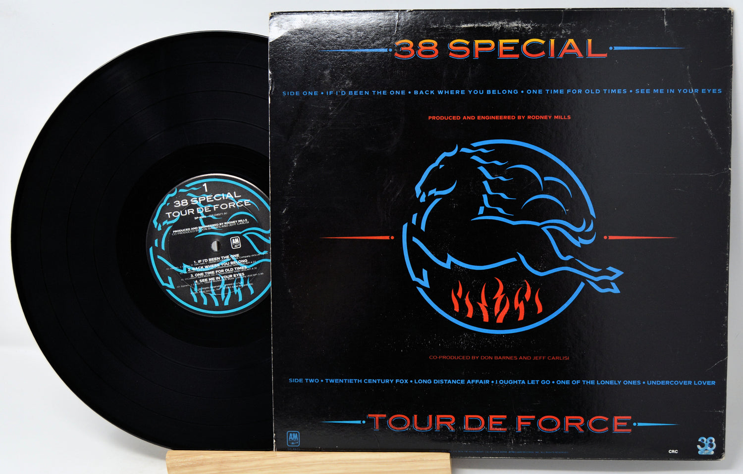 A vinyl record partially pulled from its black sleeve, showing the black disc and the cover art for 38 Special's 'Tour De Force'.