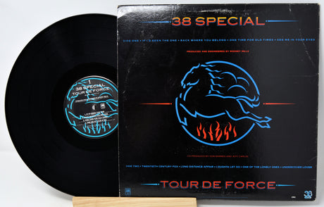 A vinyl record partially pulled from its black sleeve, showing the black disc and the cover art for 38 Special's 'Tour De Force'.