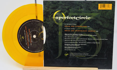 Vinyl record with yellow disc and green label featuring 'a perfect circle' on a white background