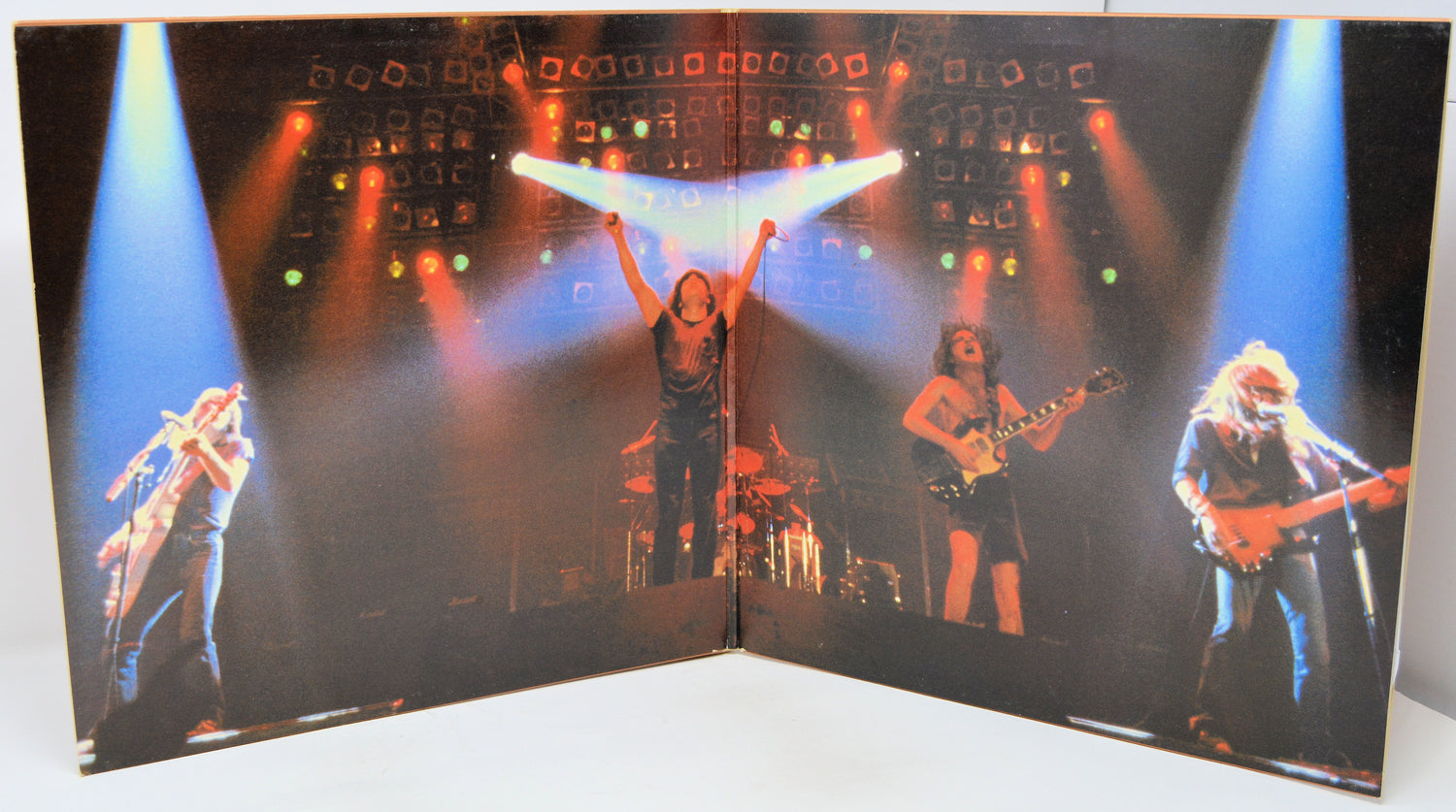 Album cover with a band performing on stage under colorful lights