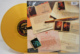 Gold vinyl record with a detailed back cover featuring text and images.