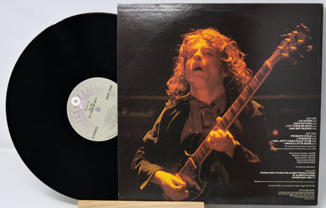 Vinyl record with a cover featuring a person playing guitar on a dark background