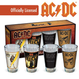 A set of four AC/DC branded 16 oz pint glasses, each with a different album image from the band's popular releases, presented in an official licensed product box.