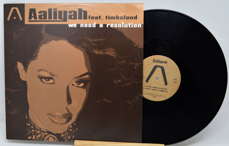Vinyl record with Aaliyah cover and black disc on a light gray background