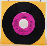 A vinyl record of Paula Abdul's album 'Vibeology' with a pink label on a yellow background.