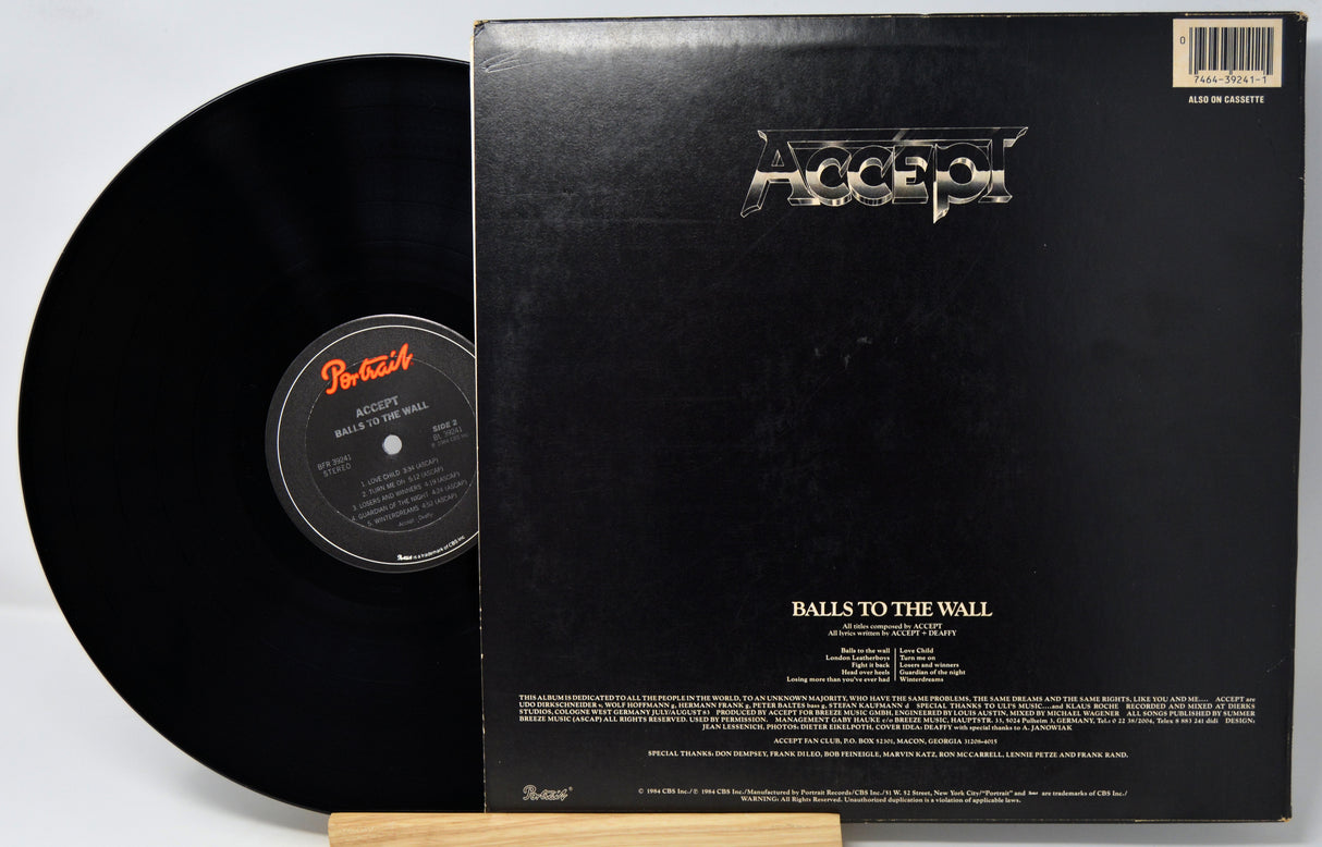 Accept's 'Balls to the Wall' vinyl record shown with the black LP partially pulled from the black outer sleeve, photographed on a white background.