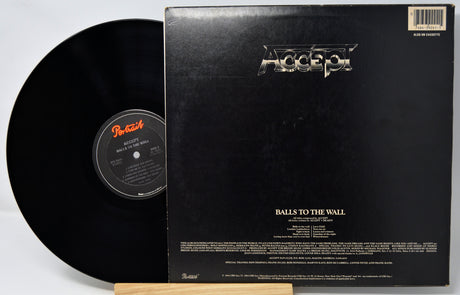 Accept's 'Balls to the Wall' vinyl record shown with the black LP partially pulled from the black outer sleeve, photographed on a white background.