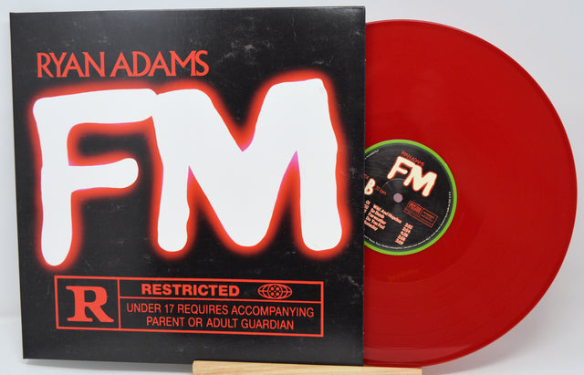 Red vinyl record with 'FM' and 'Ryan Adams' on a black cover