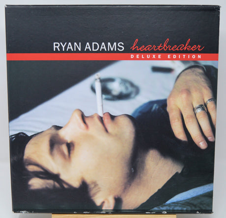 Album cover of 'Heartbreaker' by Ryan Adams with a close-up of a hand and face.
