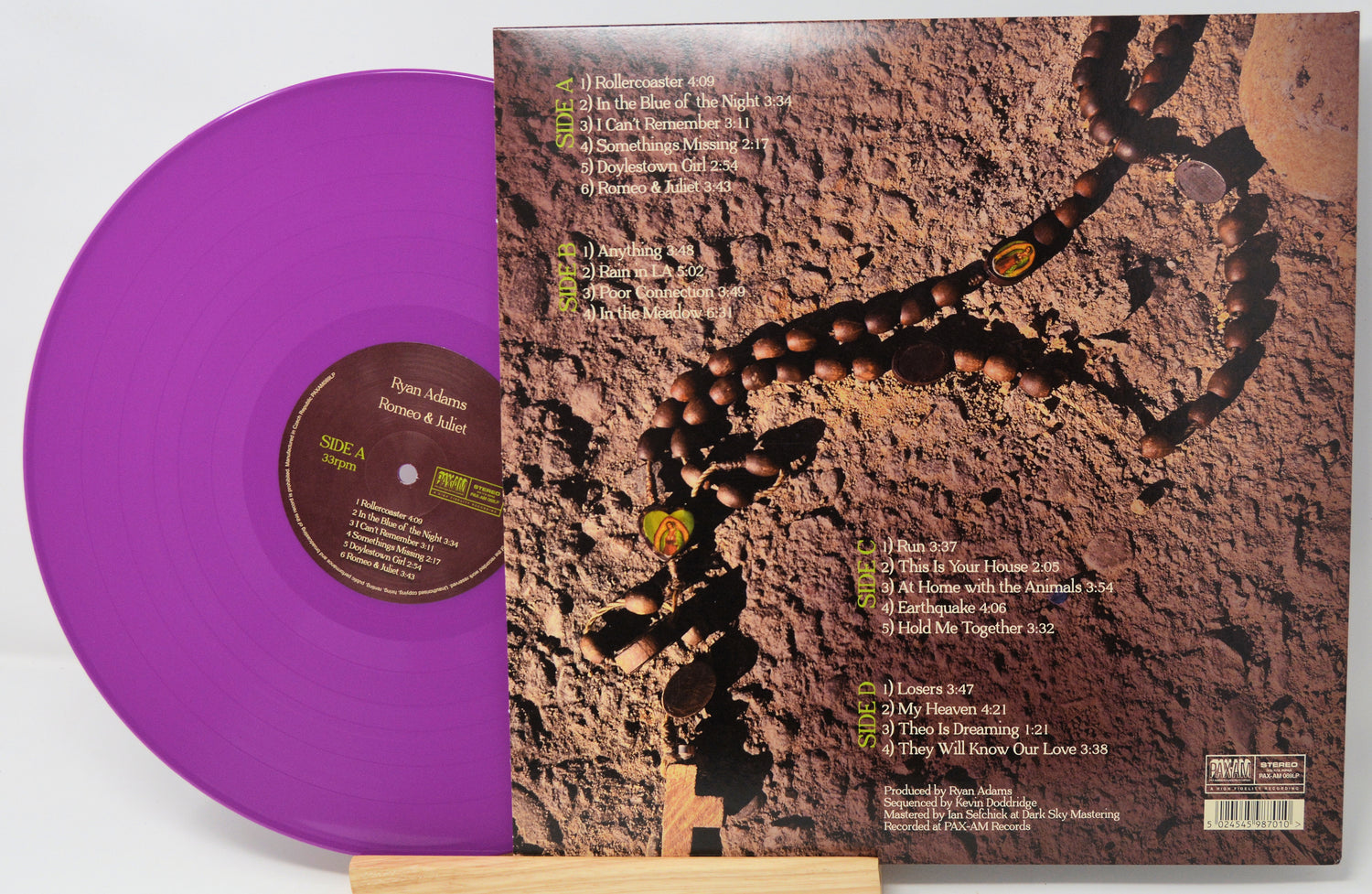 Purple vinyl record with a detailed album cover featuring text and graphics.