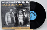 A vinyl record album of 'Achy Breaky Ha Ha Ha' by Hasil Adkins, with a picture of Hasil Adkins on the cover, placed on a record sleeve.