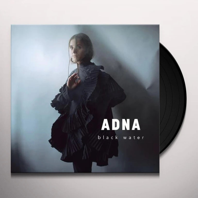 Vinyl record with 'ADNA black water' album cover featuring a person in a dark outfit.