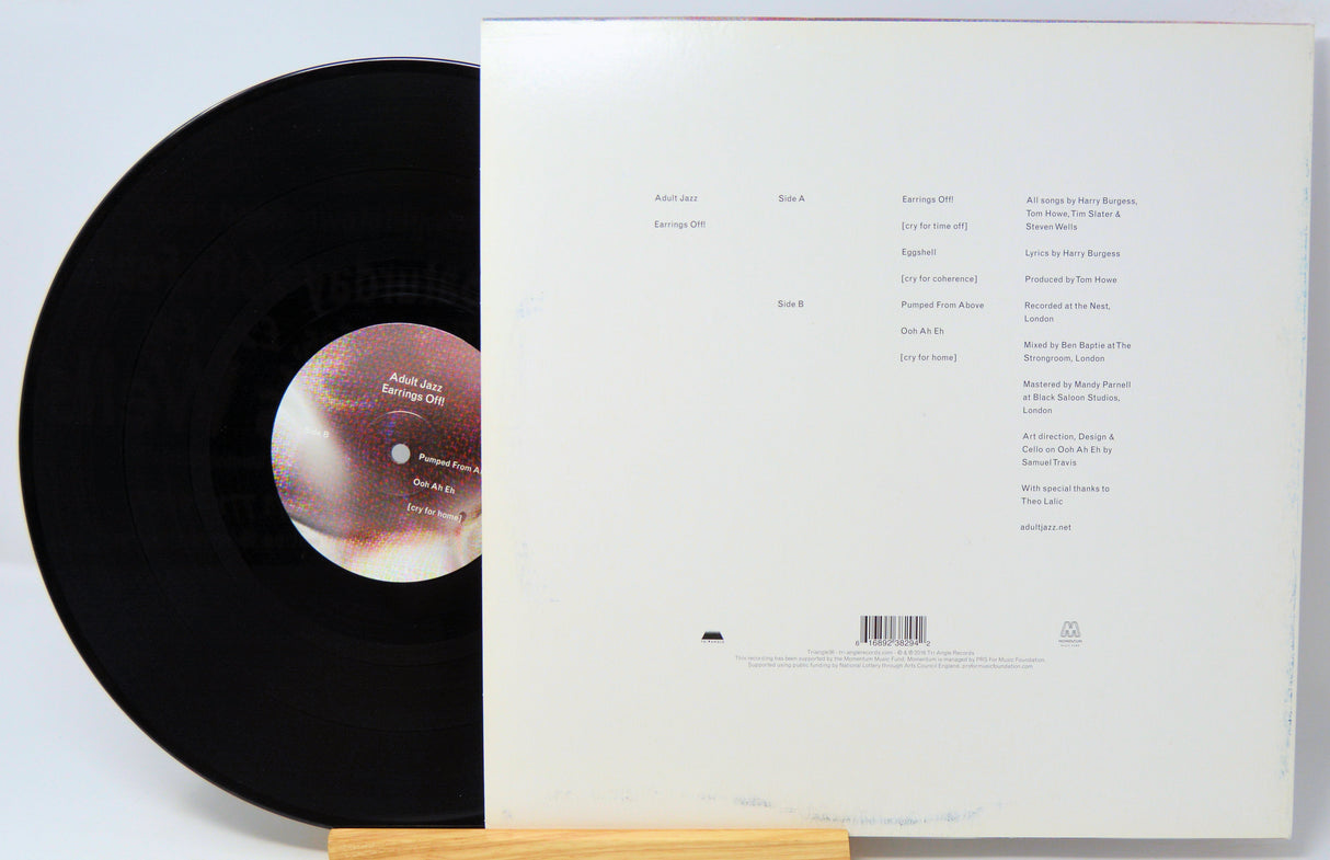 A vinyl record with a purple and black abstract design cover, and a black record disc visible underneath.