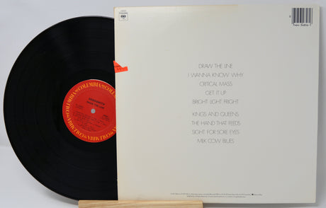 Vinyl record with a red label and its cover displaying text.
