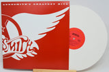 Vinyl record with red cover featuring Aerosmith logo and white wings on a white background