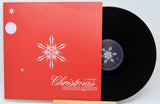 Vinyl record with red cover featuring a snowflake design and text on a light gray background
