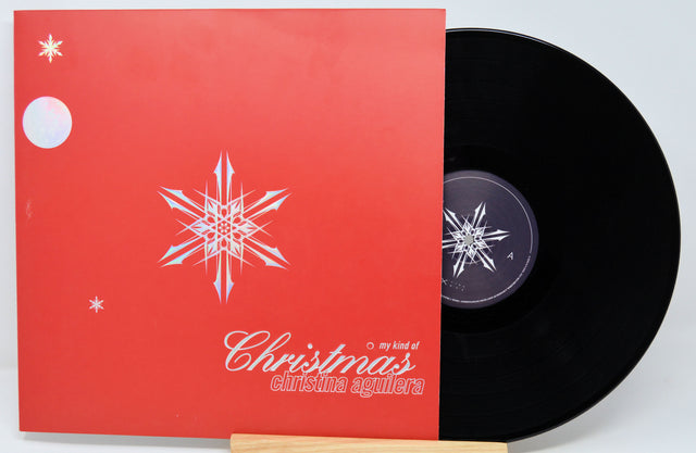 Vinyl record with red cover featuring a snowflake design and text on a light gray background