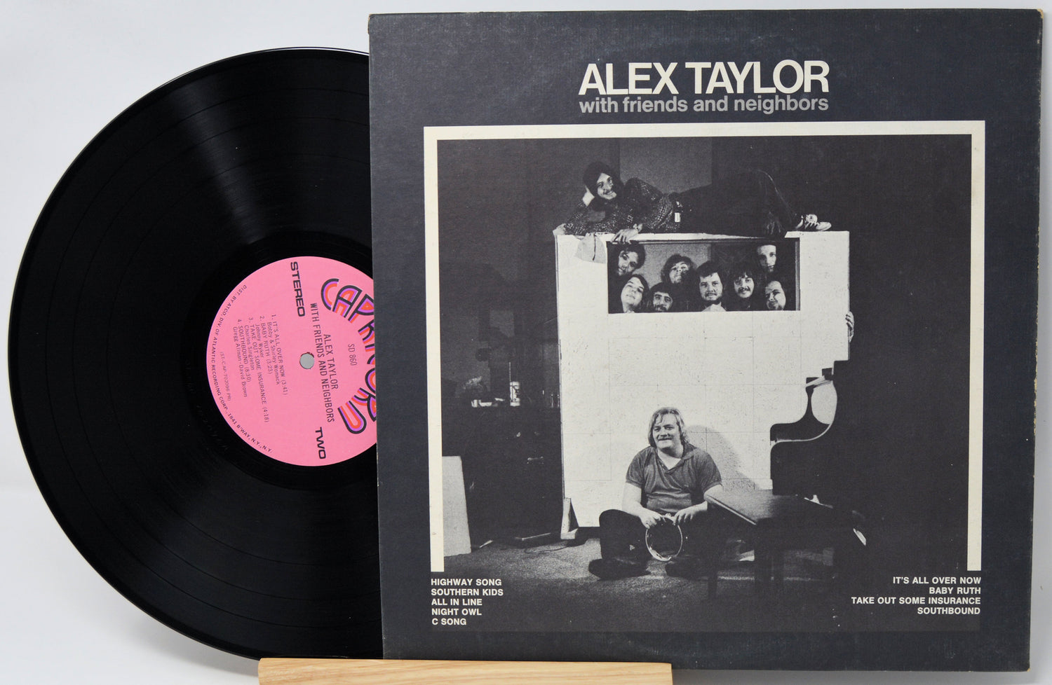 Vinyl record 'Alex Taylor With Friends Neighbors' and back cover with black and white illustration and pink label on a light gray background