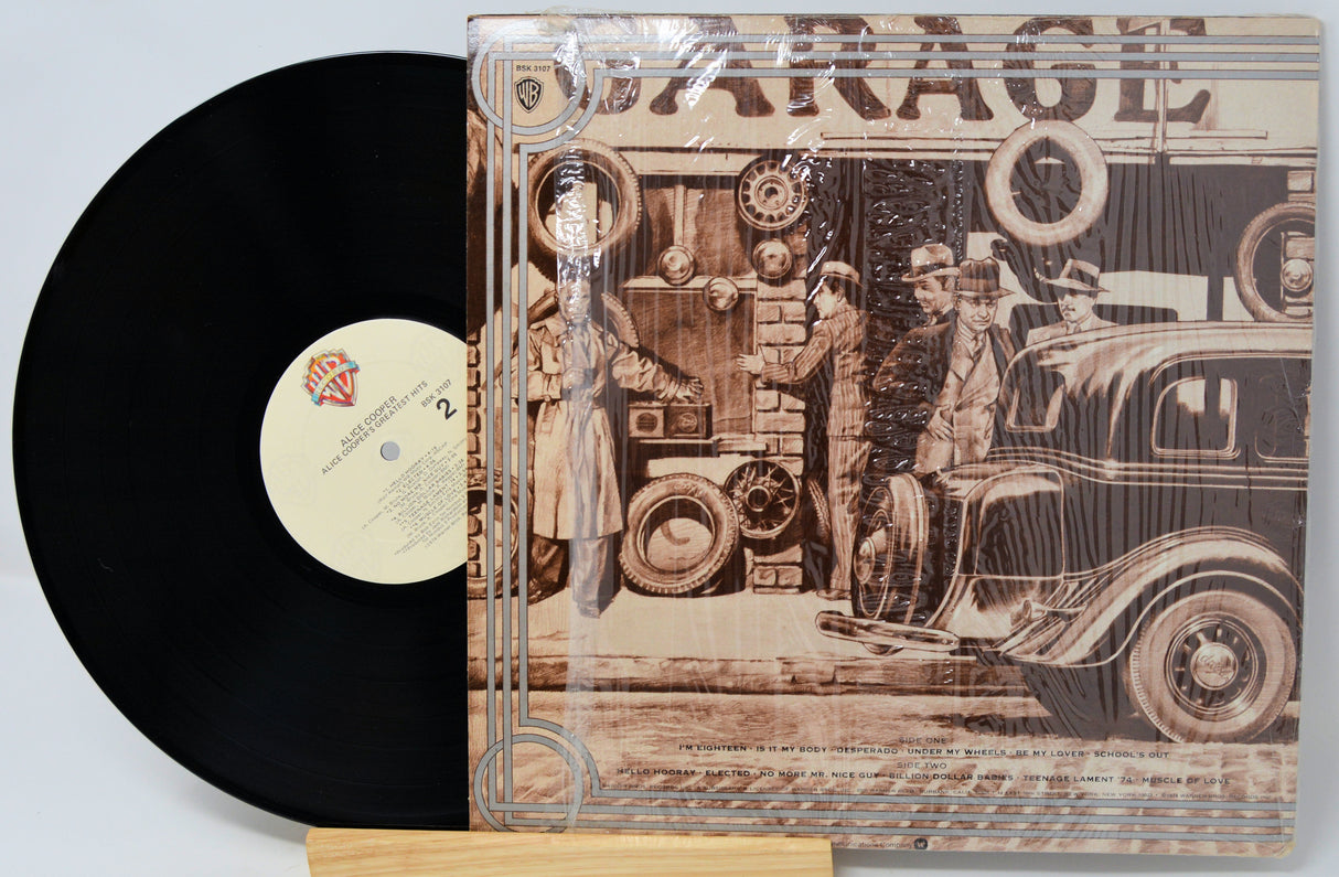 Vinyl record with a detailed cover featuring vintage cars and people, on a light gray background.