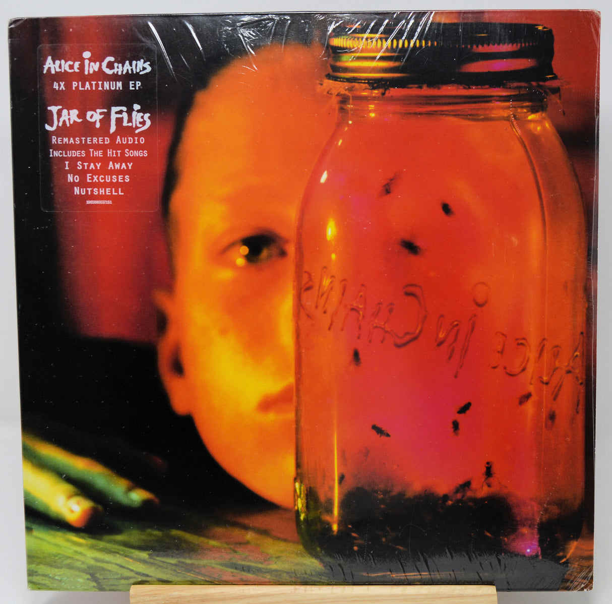 Vinyl record cover for Alice in Chains' 'Jar of Flies' with a mason jar and person's face.