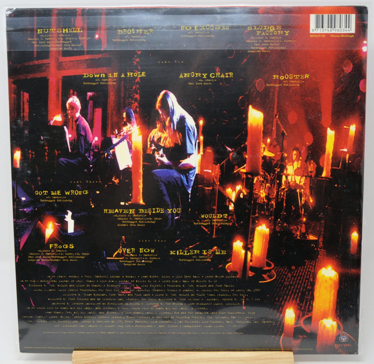 The back cover of a vinyl record sleeve for the band Rush, featuring a dramatic concert scene with musicians and glowing candles. The tracklist and barcode are visible at the top and bottom.