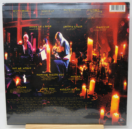 The back cover of a vinyl record sleeve for the band Rush, featuring a dramatic concert scene with musicians and glowing candles. The tracklist and barcode are visible at the top and bottom.