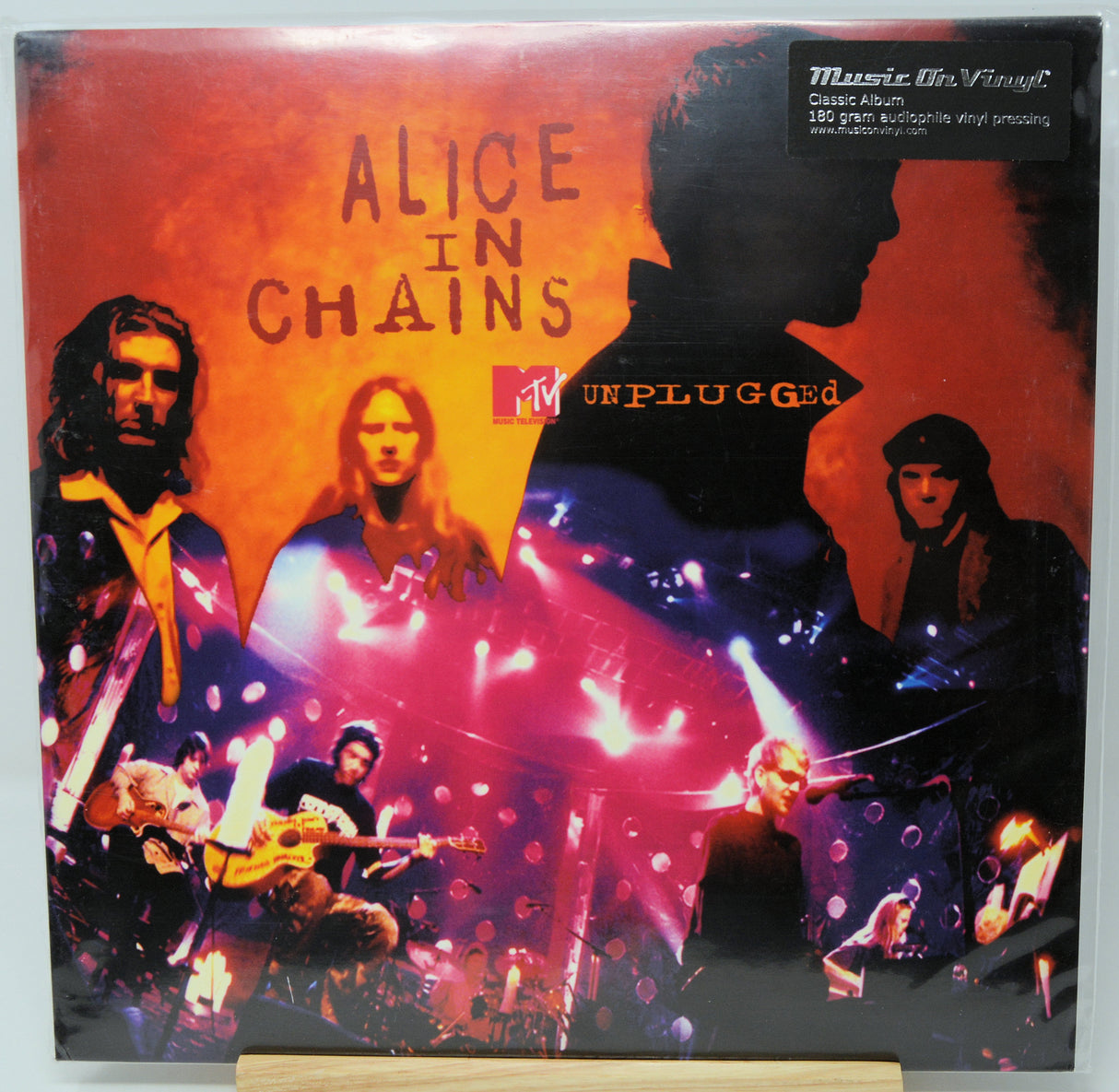 Alice in Chains ' MTV Unplugged' classic album vinyl record cover, featuring the band members and stage imagery with a black silhouette overlay, displayed on a wooden stand.