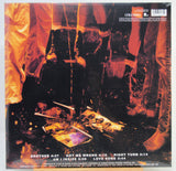 The back cover of a Columbia Records vinyl record, featuring a dark, gritty photograph with orange and yellow lighting. The tracklist is printed in white text at the bottom.