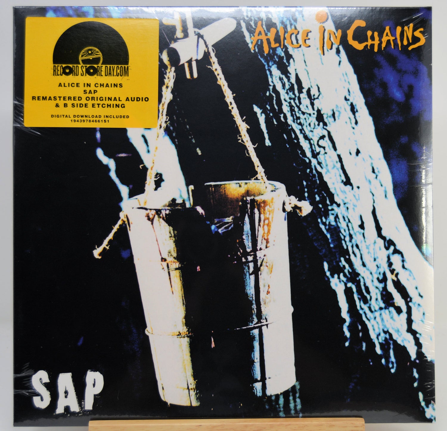 SAP's 'Alice in Chains' 12-inch vinyl record cover, featuring the band's yellow sticker on the top left and the album artwork of a hanging bucket against a dark background.