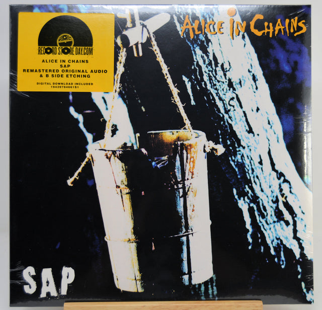 SAP's 'Alice in Chains' 12-inch vinyl record cover, featuring the band's yellow sticker on the top left and the album artwork of a hanging bucket against a dark background.