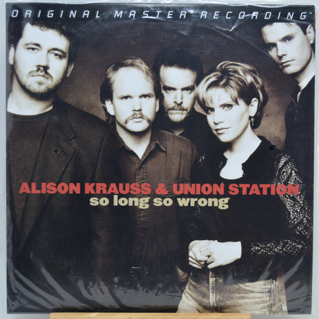 Vinyl record album cover for Alison Krauss & Union Station's 'so long so wrong', featuring a group portrait of five people against a dark studio background with red and beige text.