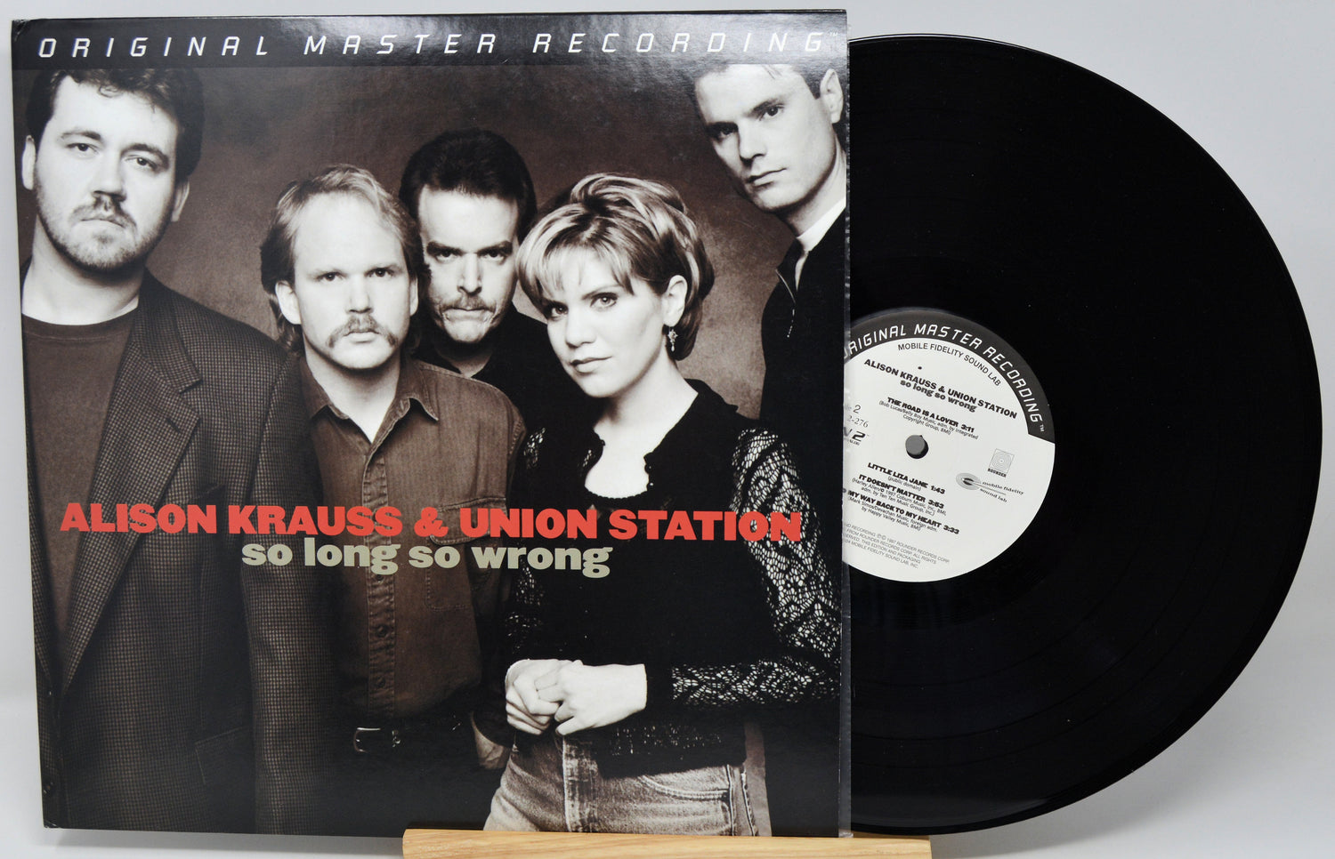 Alison Krauss & Union Station - 'So Long So Wrong' vinyl record with the album cover in front and the black LP partially visible behind it on a stand.