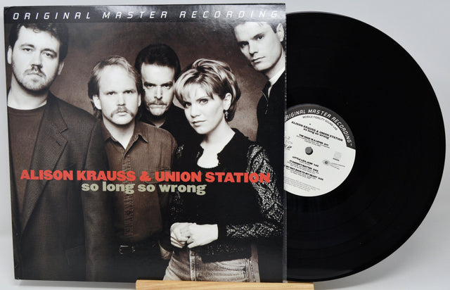 Alison Krauss & Union Station - 'So Long So Wrong' vinyl record with the album cover in front and the black LP partially visible behind it on a stand.