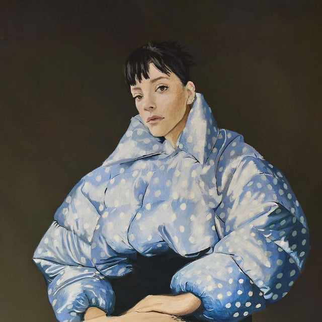 Person wearing a blue puffer jacket with white polka dots against a dark background
