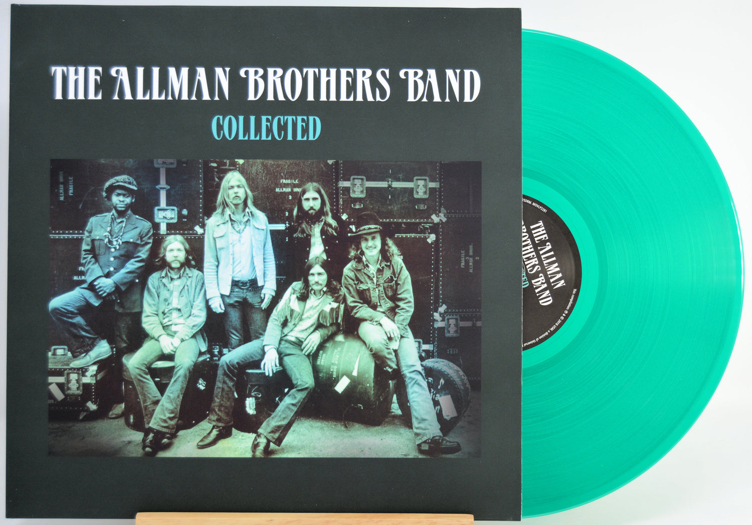 The Allman Brothers Band 'Collected' vinyl record album with a black cover and a translucent mint green record partially visible behind it.